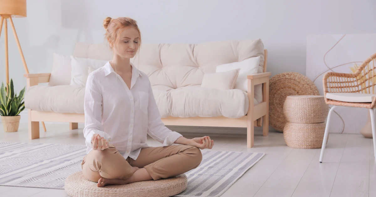 Femme en méditation assise pour débuter la méditation en pleine conscience.