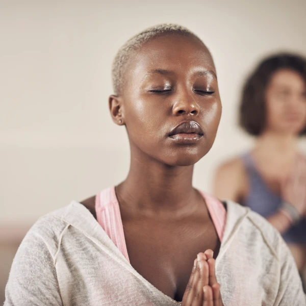 Femme en méditation les yeux fermés dans un portrait calme, illustrant la pratique de la méditation en pleine conscience.