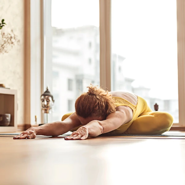 Personne en posture du papillon au sol