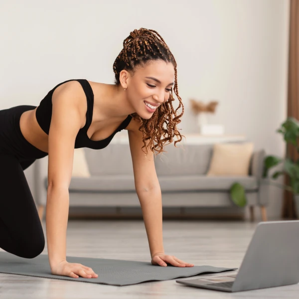 Élève suivant une formation de yoga en ligne certifiante depuis chez elle