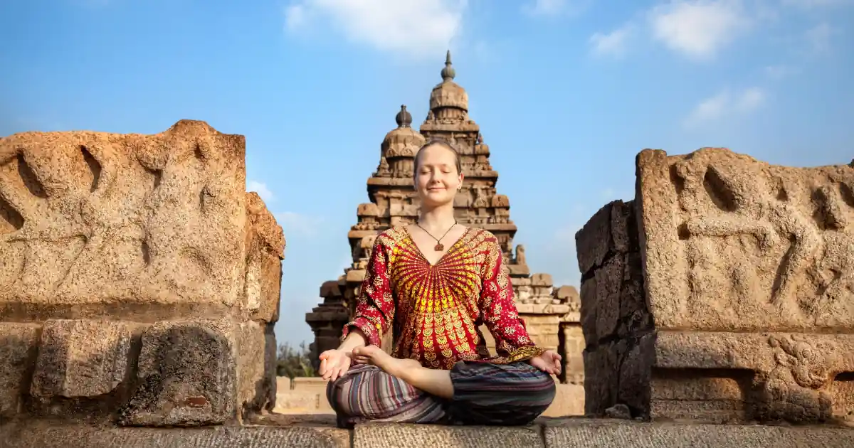 Pratique méditative devant un ancien temple en Inde, rappelant les origines du Hatha.