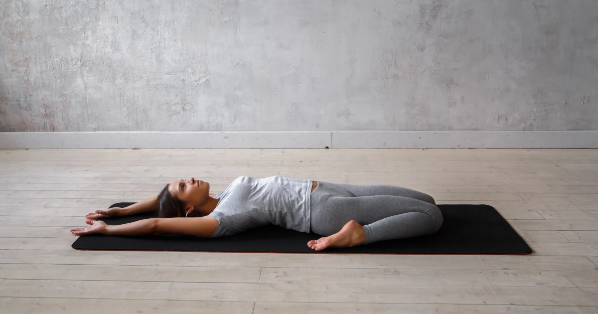 Femme allongée illustrant une ouverture douce qui soutient la mobilité en Yin Yoga.