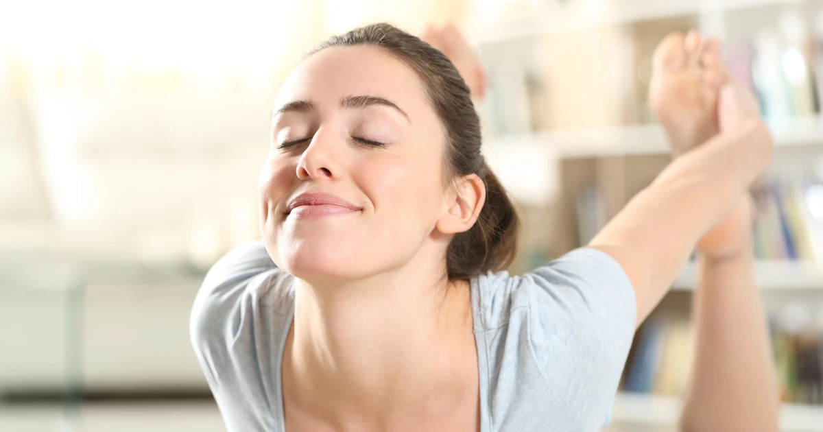 une pratiquante respire dans une posture de yoga pour ressentir le bien-être mental